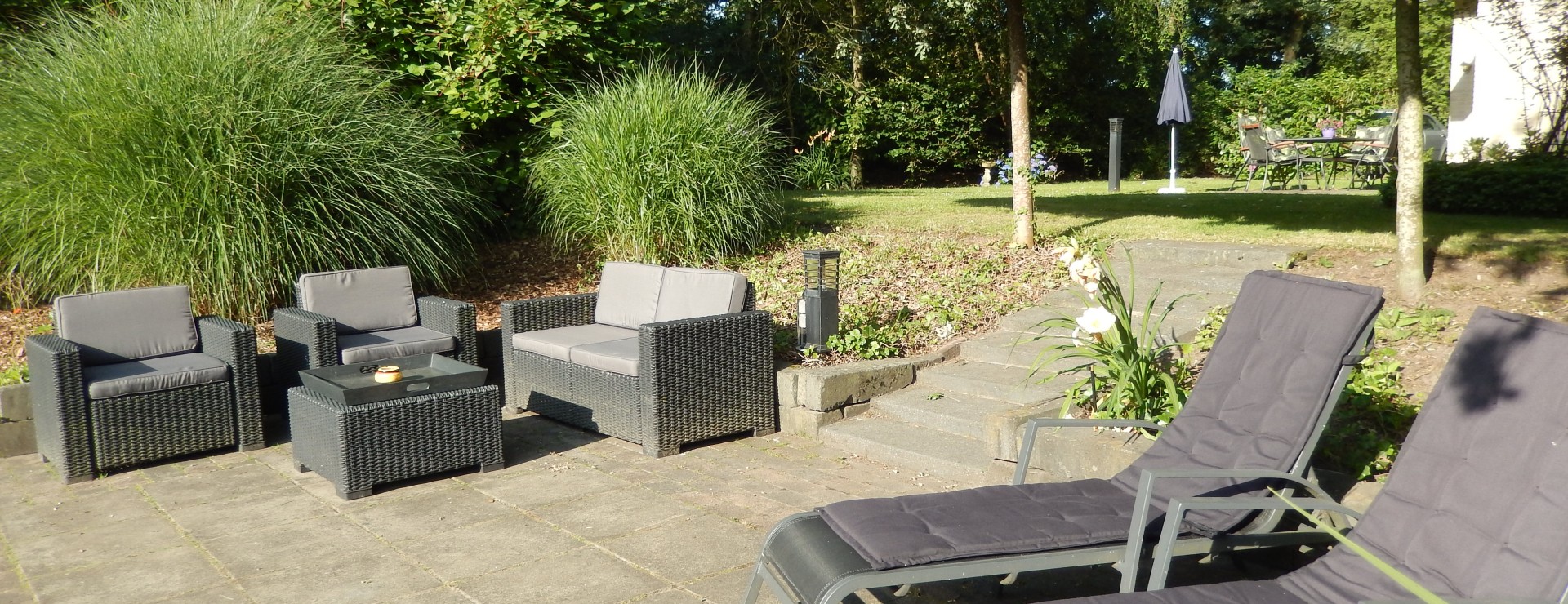Terras aan het water met ligstoelen.JPG